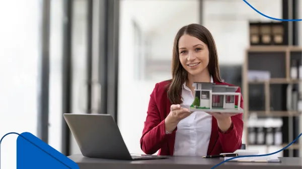 Una asesora inmobiliaria que se encuentra mostrando una casa a escala que ha sido mostrada en donde publicar venta de casa.